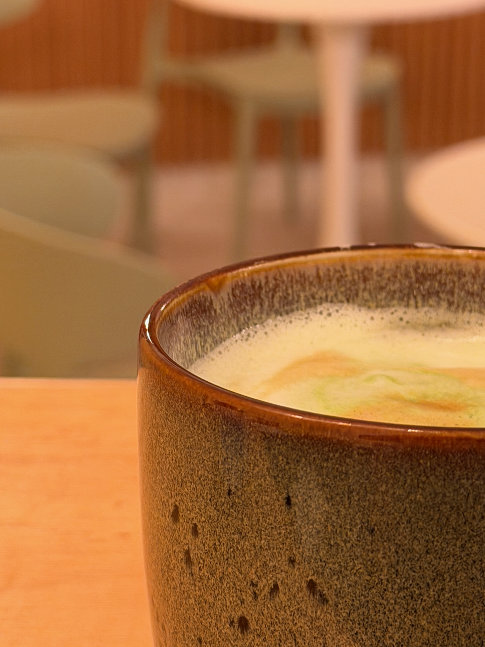 Taza de café con leche sobre mesa de madera